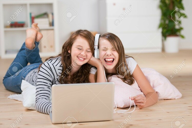 20736106-deux-heureux-jeunes-adolescentes-partageant-un-casque-relié-à-un-ordinateur-portable-pour-écouter-de-la-.jpg